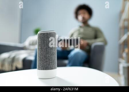 Young Man Using Wireless Speaker At Home Stock Photo