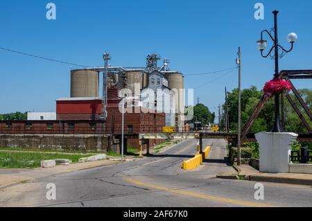 A collection of grain elevators beside some railroad tracks. Stock Photo