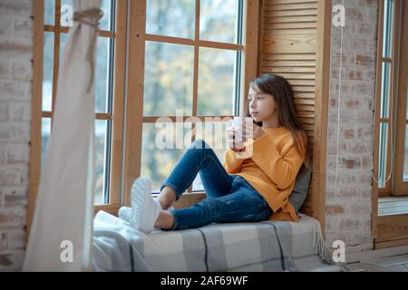 Cute girl with long hair having morning tea Stock Photo