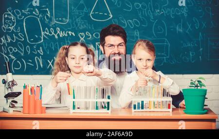 Fascinating biology lesson. Man bearded teacher work with microscope and test tubes in biology classroom. School biology experiment. Explaining biology to children. How to interest children study. Stock Photo