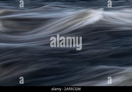 Close up from flowing water in long exposure shot. River rapids. Stock Photo