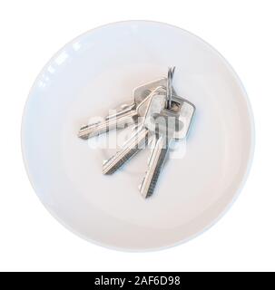 Bunch of keys on white saucer white background Stock Photo