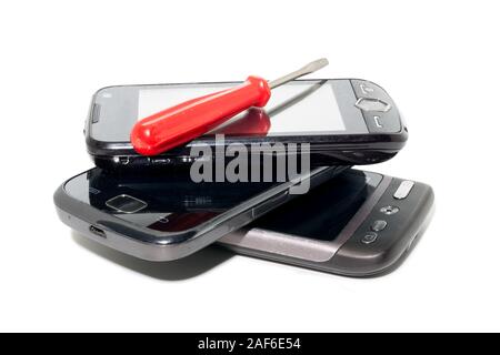 Repair of three black smartphones and screwdriver isolated white background Stock Photo