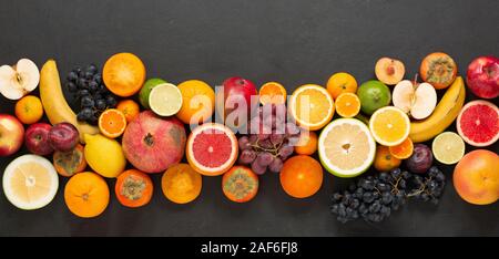 Strip of fruits on a black concrete background. An abundance of delicious healthy fruits. Stock Photo
