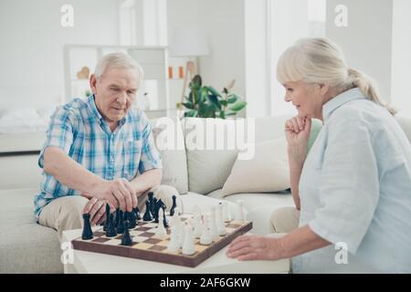 Profile side view portrait of her she his he two nice attractive minded bewildered concentrated focused people playing chess spending time in light Stock Photo
