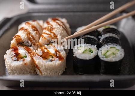 sushi box or bento box with assorted sushi rolls pieces. Fish food selective focus. Stock Photo