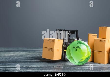 Green glass globe and forklift truck with cardboard boxes. Distribution and trade exchange goods around the world, retail and sales. Global business, Stock Photo