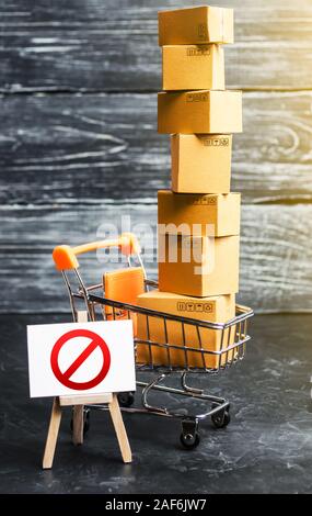 Trading cart with boxes and an easel with a prohibition symbol NO. Internet trade online shopping ban. Restriction on importation goods, proprietary f Stock Photo