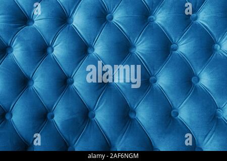 Blue fabric sofa texture with buttons for background and design. Color of the Year 2020 Classic Blue Stock Photo