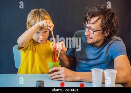 Father and son conduct chemical experiments at home. Home made slime. Family plays with a slime Stock Photo