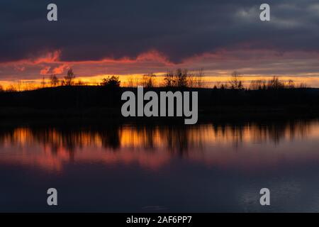 Wonderful sunset over the water, colorful clouds and the reflection of light in the lake water Stock Photo