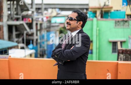 Business handsome man posing in style clothing and trendy sun glasses on outdoors backgrounds Stock Photo