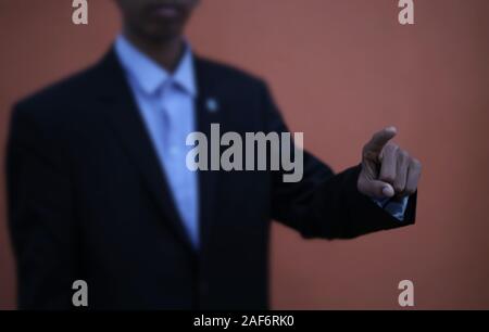 Businessman in black suit is pointing his finger to touch Stock Photo