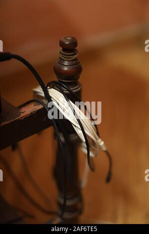 Smartphone cable or broken phone cable hangs on desks Stock Photo