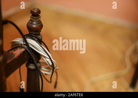 Smartphone cable or broken phone cable hangs on desks Stock Photo