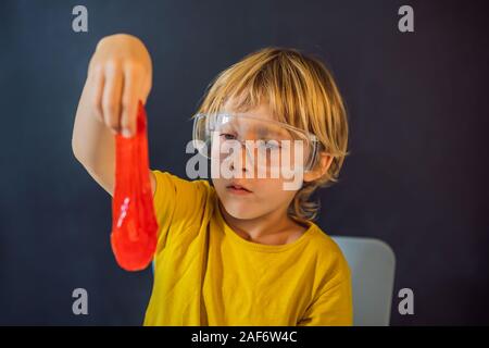 Boy playing hand made toy called slime. Child play with slime. Kid squeeze and stretching slime Stock Photo