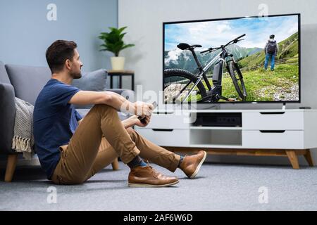 Man Streaming Television Channel Through Wireless Connection On Digital Tablet Stock Photo