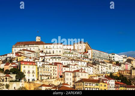 View of the high of Coimbra, Portugal, with its old houses up the hill to the University Tower on a sunny day with blue sky. Stock Photo