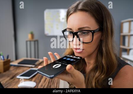 Close-up Of An Woman Using Voice Assistant On Cellphone Stock Photo