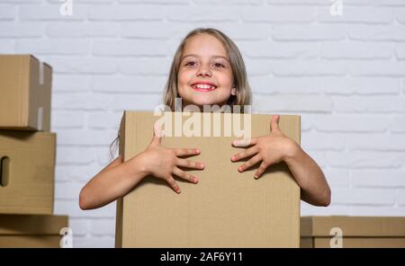 Packaging things. Move out concept. Delivering your purchase. Kid moving out. Moving routine. Prepare for moving. Rent house. Real estate. Make moving easier. Girl small child carry cardboard box. Stock Photo