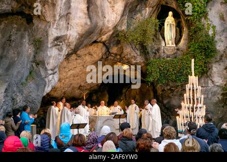 Praying at a morning mass or service, Grotte de Massabielle / Grotto of Massabielle, Sanctuary of Our Lady of Lourdes, Lourdes, Pyrenees, France Stock Photo