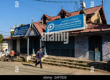 A quaint, old structure with stone walls, gables, wooden boards and slanting tin roofs that houses an Indian bank in Almora. Stock Photo