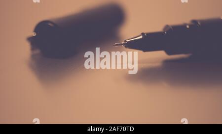 Black pen on a white notebook paper, accessory for creativity on the table Stock Photo