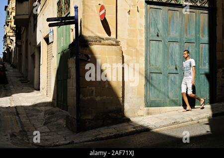 Young man walking on the street in Valletta, Malta Stock Photo