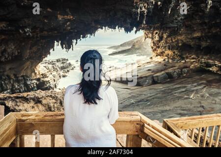 Woman watching Sea Lions through Admirals Arch lookout, Kangaroo Island, South Australia Stock Photo