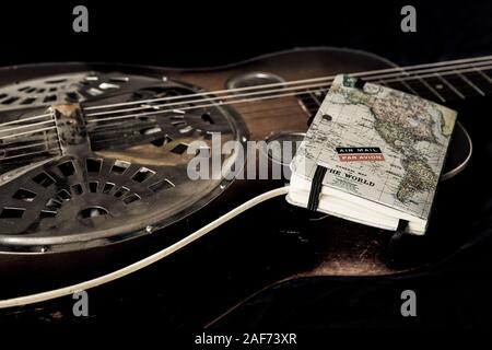 A Dobro guitars and a diary on a black background Stock Photo