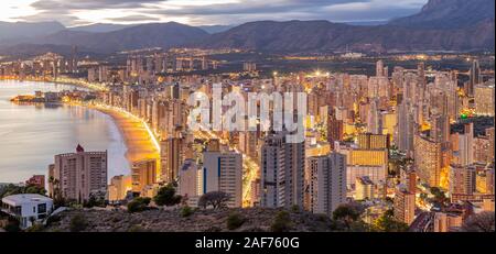Benidorm Levante beach promenade at sunset with bright reflections in high rise buildings in the dusk light. Stock Photo
