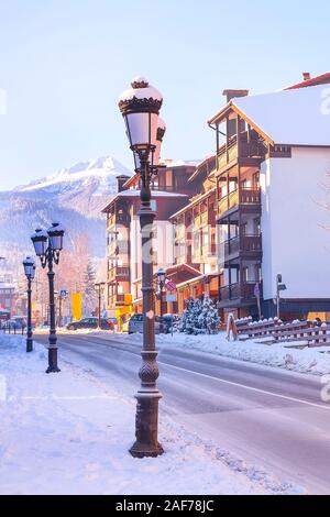 Bansko, Bulgaria Pirin street view and Todorka snow mountain peak in bulgarian ski resort Stock Photo