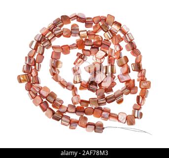 top view of tangled string of beads from natural pink pieces of mother-of-pearl isolated on white background Stock Photo