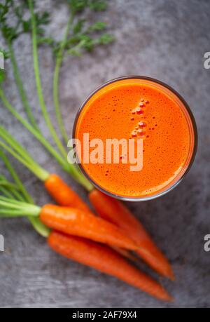 Overhead view of fresh carrot juice on a gray surface Stock Photo