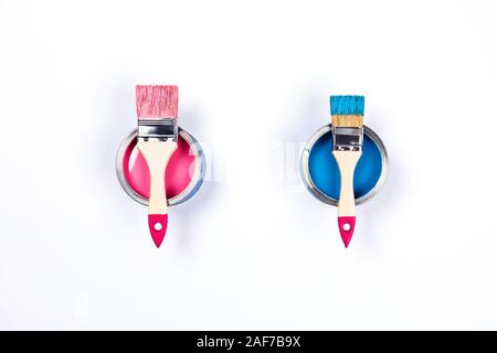 Repair picture. Classic blue and pink paint cans with two paint brushes located on it. Isolated background. Flat lay, top view, copy space. Stock Photo