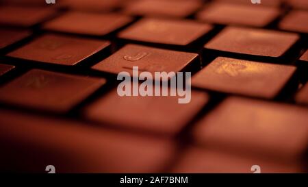 Black keyboard lit by red light, macro photo. Stock Photo