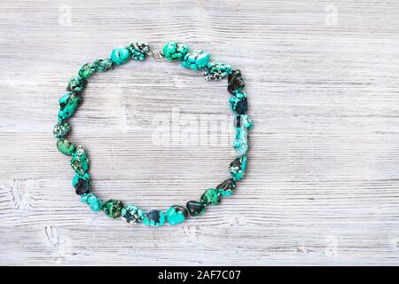 top view of colored howlite (turquoise imitation) necklace on gray wooden board with copyspace Stock Photo