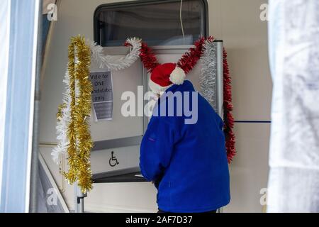 Picture dated December 12th shows voters in the village of Carlton,Cambs,voting in a caravan for todayÕs General election with Christmas tinsel around the polling both.It is the first December election since 1923.   Voters headed to a variety of unusual polling stations for todayÕs (Thurs) General Election - which is the most important for a generation. Villagers in rural Carlton, near Newmarket in Suffolk, have been voting in a tiny CARAVAN parked outside the Old Rectory. The small caravan pulled-up outside Robin WylieÕs house last night and around 100 people are expected to vote there today. Stock Photo