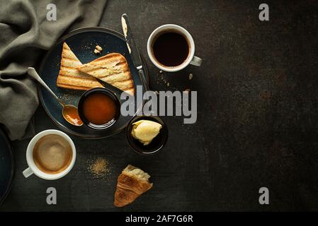 Continental Breakfast meal served with coffee, croissant, toast, jam and butter. Delicious coffee table. Stock Photo