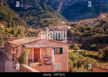 Typical Spanish houses in Valldemossa town, surrounded by mountains and trees, sunny day,, Mallorca, Spain. Stock Photo