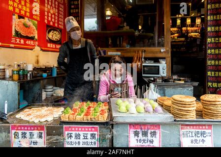 March, 15. 2019: Couple selling food on street of Lijiang's old town (Dayan). Yunnan, China Stock Photo