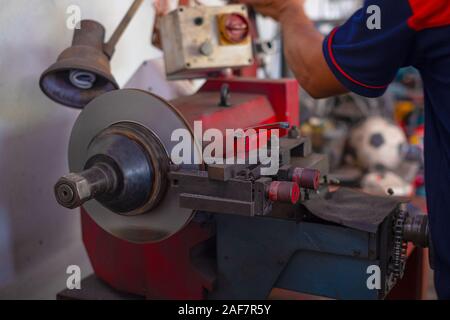 Mechanic man repairing brake use lathe tool polishing disc brakes of cars working automatic Stock Photo