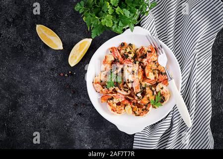 Grilled shrimps. King prawn tails in orange-garlic sauce with parsley. Top view, copy space