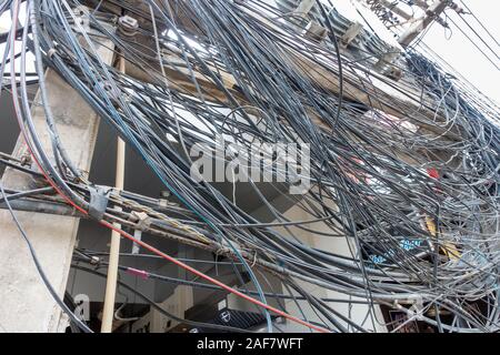 Chaotic electricity supply, hundreds of wires around poles Stock Photo