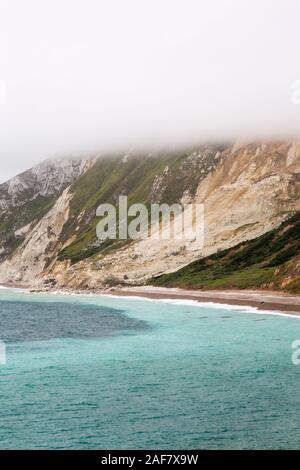 Low cloud partly obscures the full extent of a massive chalk cliff fall and slump in Worbarrow Bay near Tyneham, Dorset, England, UK Stock Photo