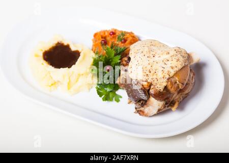 Baked pork knuckle with mustard sauce and mashed potato and stewed cabbage Stock Photo