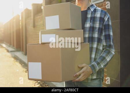 Man in shirt hold blank boxes outdoor, space for text Stock Photo