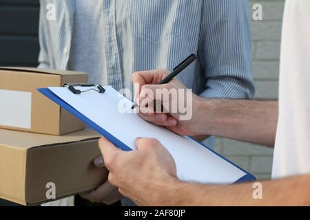 Man with boxes and delivery man outdoor, blank space Stock Photo