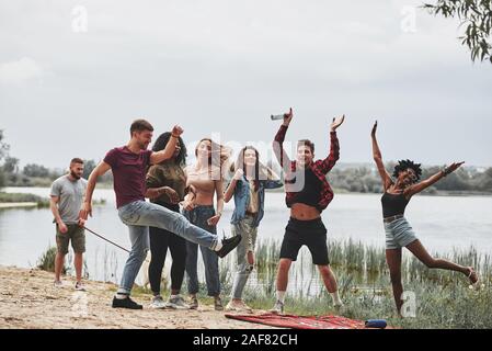 Positive mood. Group of people have picnic on the beach. Friends have fun at weekend time