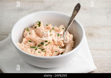 bowl of  pate  salmon with soft cheese and herb,  a textile napkin on a wooden table Stock Photo